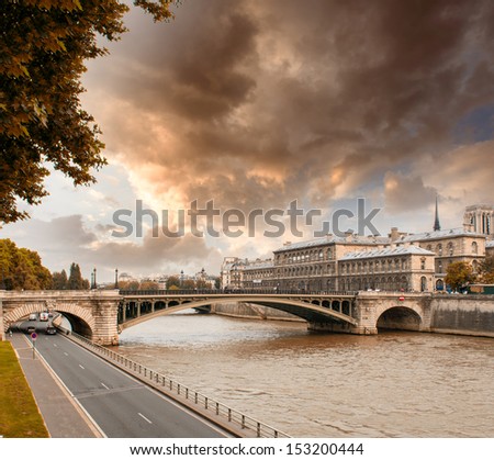 Notre Dame Bridge in Paris with Seine river and city traffic.