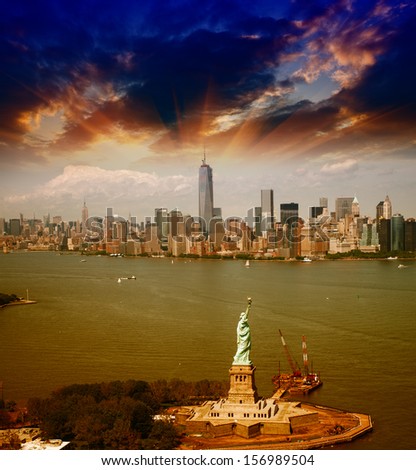 Statue of Liberty and Manhattan skyline. Spectacular helicopter view at sunset.