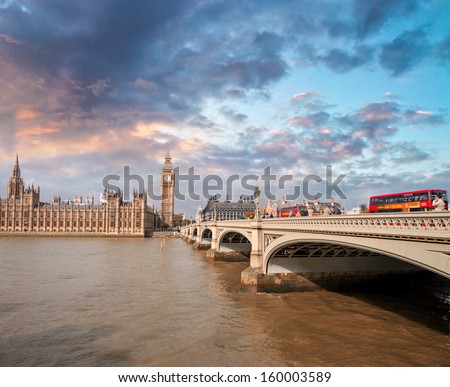 Two Red Double Decker Buses speeding up on Westminster Bridge in London.