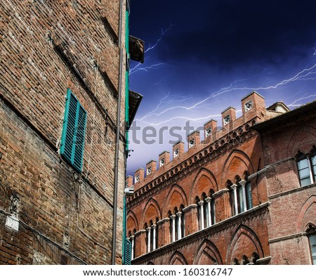 Ancient medieval homes of Tuscany small town. View with storm.