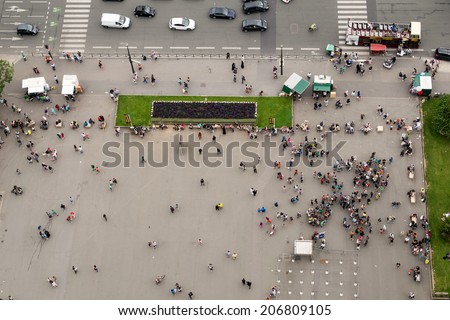 Crowd at the the base of Eiffel Tower in Paris. View of tiny people from landmark top.