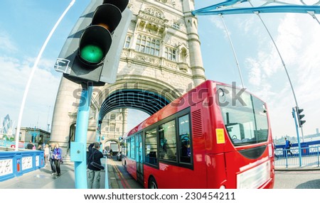 Double Decker red bus crossing Tower Bridge.