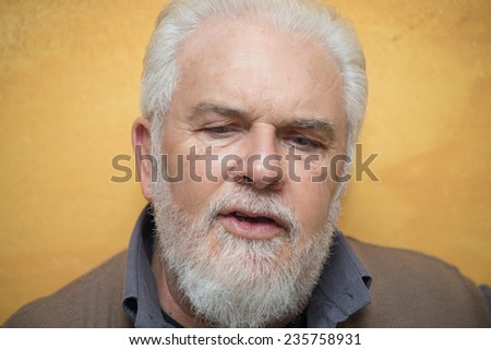 Mature man with white beard talking at home. Family and relax concept.