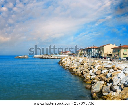 Rocks over the oceans. Beautiful seascape with village homes at sunset.