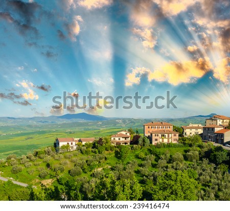 Italian landscape, Tuscany meadows and homes at sunset.