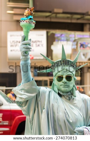 NEW YORK CITY - JUNE 9, 2013: Man in Times Square pretends to be Statue of Liberty. Times Square is a popular tourist destination in New York City.