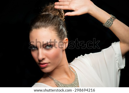Beautiful brunette model protecting her face with hand. Isolated on black.