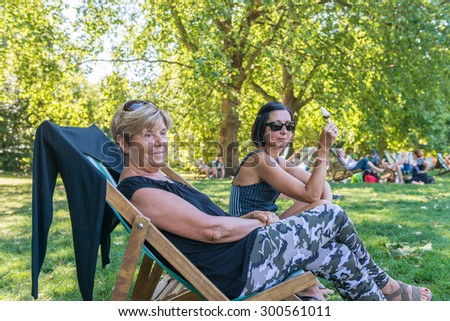 Different generations women relaxing on park chairs.