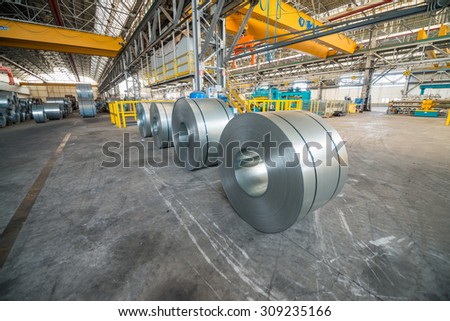 Cold rolled steel coils in storage area ready to feed to machine in metalwork manufacturing.