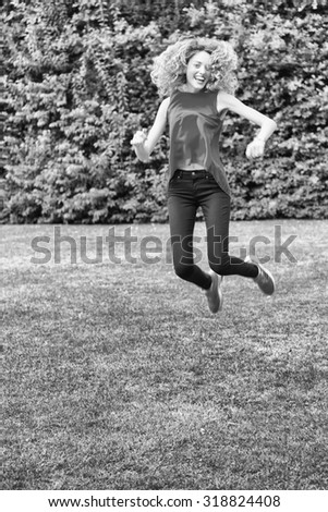 Alone blond woman jumping for joy on a grass. One happy slim girl fly in a green field, Idea of success, growth , light, diet, luck, freedom.