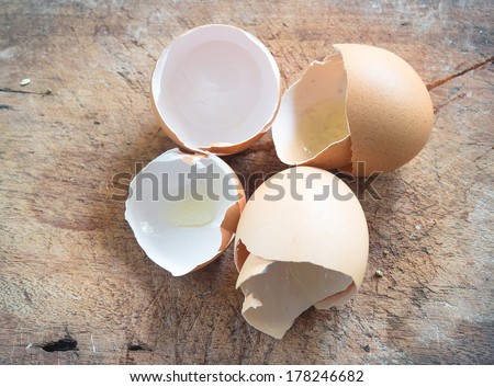 a pile of broken empty brown chicken eggshell  on wood