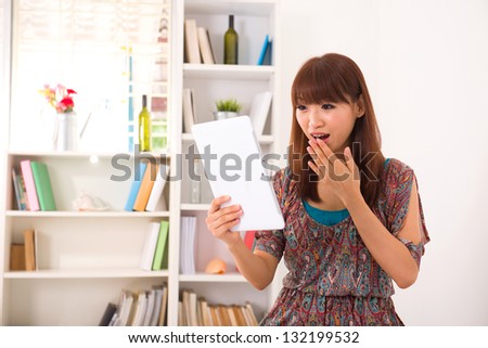 Portrait of smiling chinese woman using laptop with livingroom background