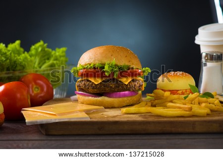 cheese burger with plenty of fast foods ingredients on the background