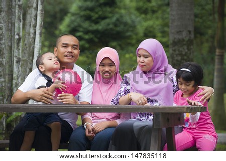 malay family having fun in the green outdoor park