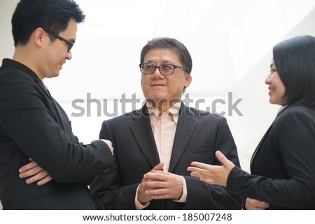 asian business team meeting with senior ceo with office background