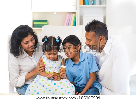 happy indian family enjoying eating ice cream indoor