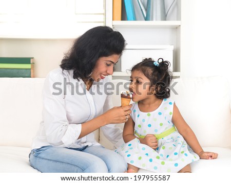 indian mother enjoying ice cream with her daughter on lifestyle background