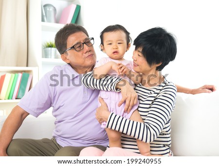 asian grand parents comforting their spoilt crying grand daugther