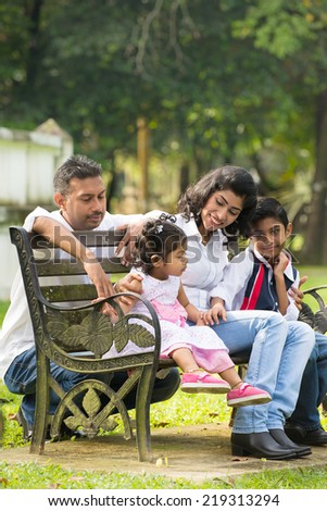 indian family sitting on the bench in the park