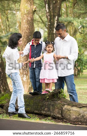 happy indian family walking outdoor in the park