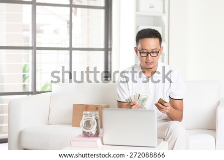 asian male enjoying cash back credit card