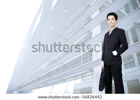 young asian business man holding a suitcase with office background