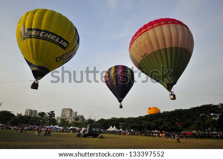 PUTRAJAYA, MALAYSIA - MARCH 30:Three tethered hot air balloons float on the air during 5th Putrajaya International Hot Air Balloon Fiesta at Putrajaya on March 30, 2013.