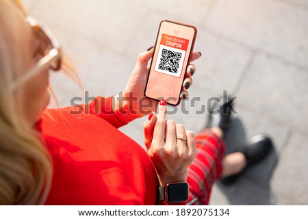 Woman viewing discount coupon on mobile phone Сток-фото © 