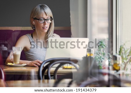 Young woman working with computer in cafe