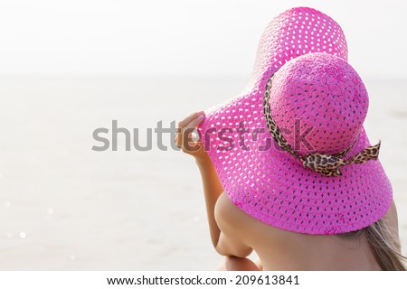 Young woman with beach hat looking into distance