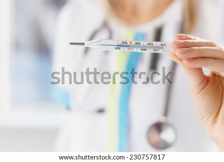 Doctor holding thermometer