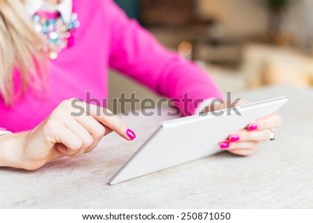 Woman using internet on tablet computer in cafe