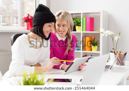 Two women working together and using tablet computer