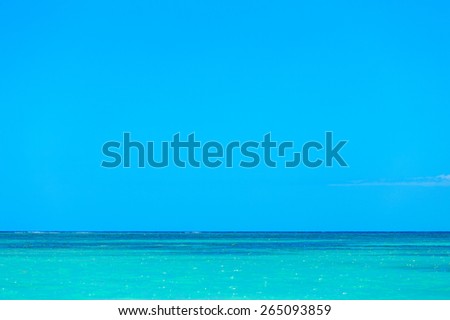 Simple background of turquoise blue sea water and clear blue sky