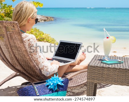 Business woman working with computer on the beach