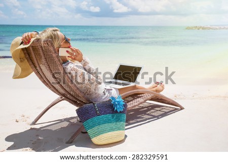Productive businesswoman working on the beach