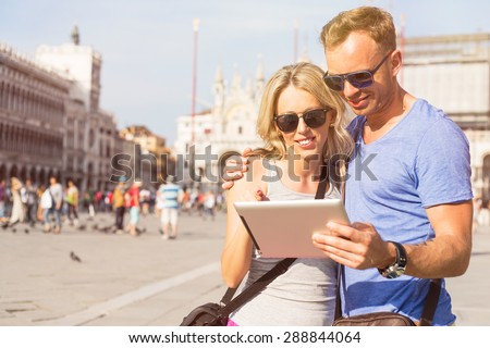 Couple looking at tablet computer while traveling in Venice