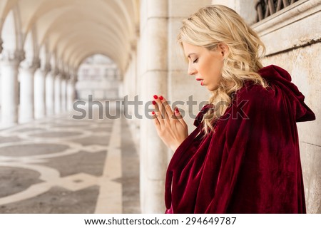 Woman in red cloak praying