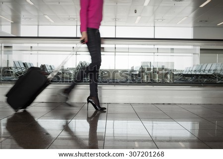 Woman walking in airport, blurred in motion