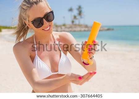 Woman pouring sun protection cream in hand