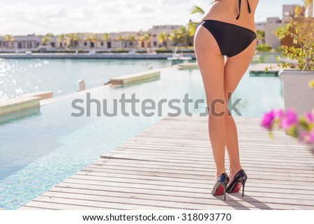 Woman wearing high heel shoes by the pool