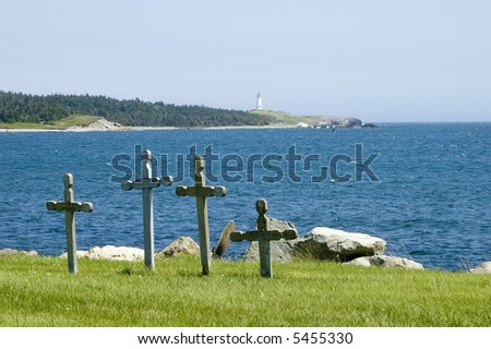 Four stone grave markers in a cemetery at water\'s edge