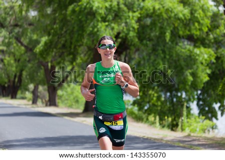 COEUR D ALENE, ID - JUNE 23: Heather Wurtele of Canada runs along Lake Coeur d\'Alene by herself at the June 23, 2013 Ironman Triathlon in Coeur d\'Alene, Idaho. Heather won the woman\'s division.