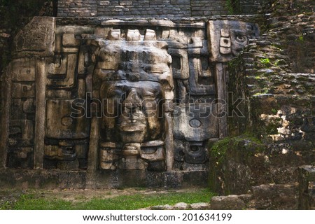 An Olmec style face adorns the side of the Mask Temple at the Mayan site of Lamanai in Belize.