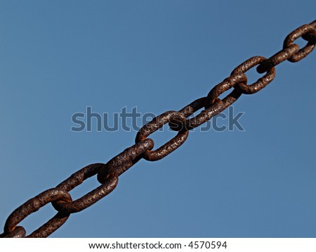 Rusty chain links connected together on a diagonal against a blue sky