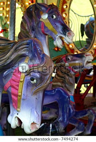 Carousel horses against the bright colors of the merry-go-round