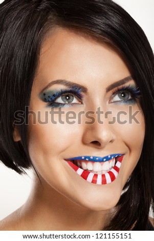 Woman beautiful face with perfect makeup. on the lips and eyes painted an American flag
