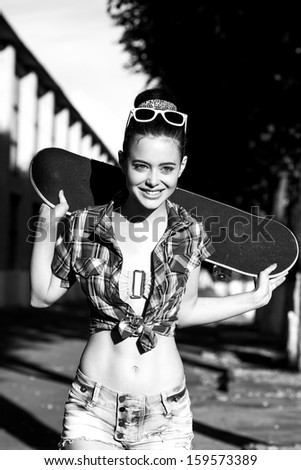 Trendy happy girl in  summer dress with skateboard. Outdoors. Urban lifestyle shot.