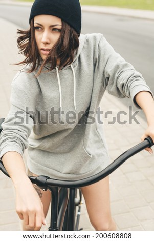 Young hipster girl with black bike. Outdoor lifestyle portrait
