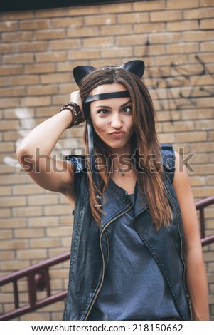 Bad sexy woman with leather cat ears. Urban scene. Outdoor lifestyle portrait